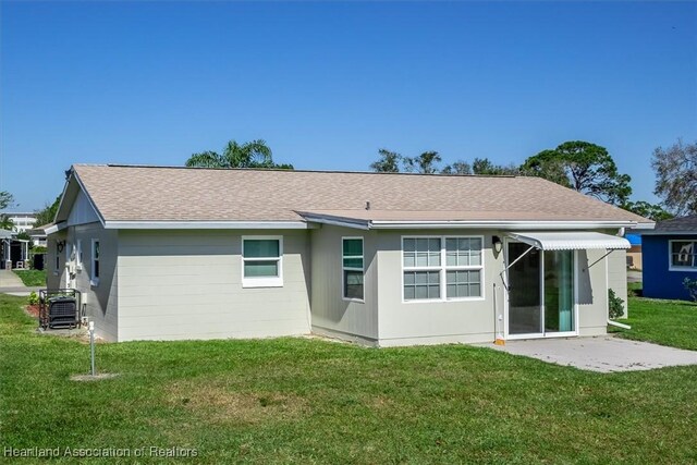 back of house with cooling unit, a lawn, and a patio area