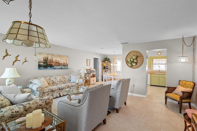 tiled living room with sink and a textured ceiling