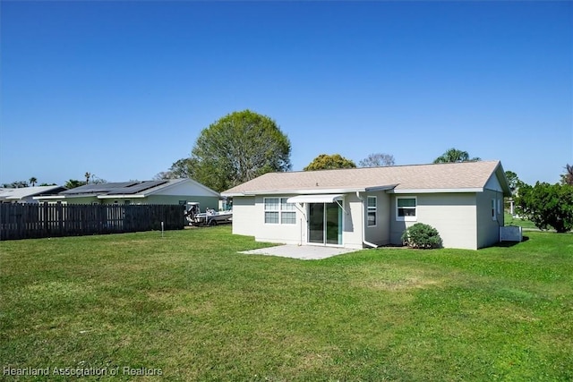 rear view of house featuring a patio area and a lawn