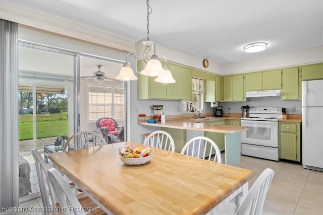 kitchen featuring light tile patterned flooring, white appliances, kitchen peninsula, and green cabinets