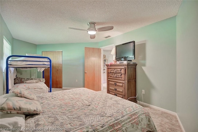 carpeted bedroom featuring a textured ceiling and ceiling fan