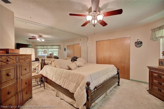 bedroom with a textured ceiling and light colored carpet