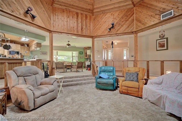 living room with a high ceiling, carpet floors, and wooden walls