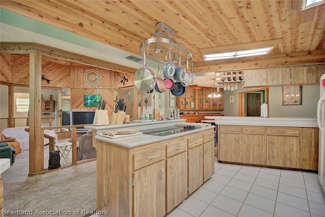 kitchen featuring wooden walls, lofted ceiling, black electric cooktop, wood ceiling, and a center island