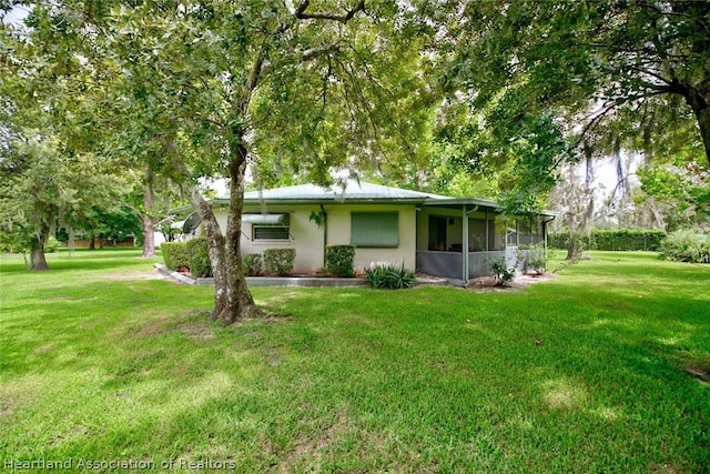 view of front of home featuring a front yard and a sunroom