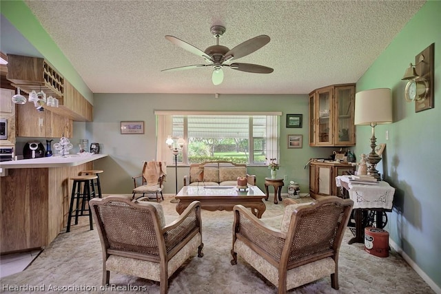 living room featuring ceiling fan and a textured ceiling