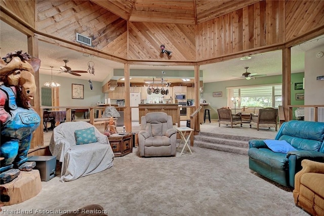 living room featuring ceiling fan with notable chandelier, wooden walls, carpet floors, and a towering ceiling