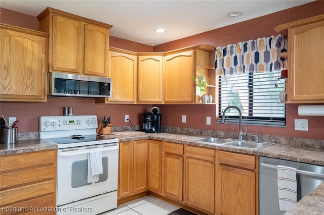 kitchen with appliances with stainless steel finishes, sink, and light tile patterned floors