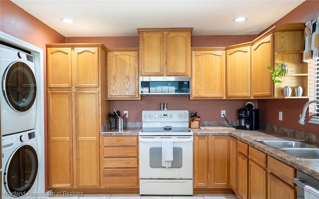 kitchen featuring sink, stainless steel appliances, and stacked washing maching and dryer