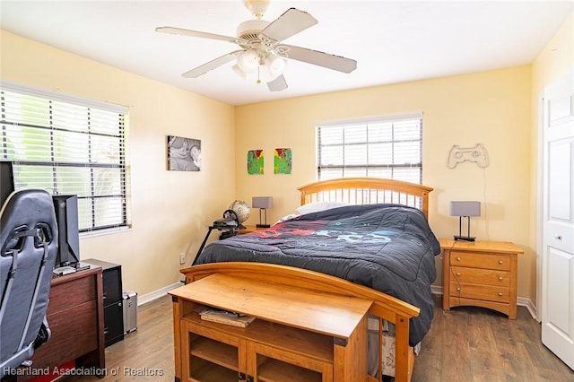 bedroom with dark hardwood / wood-style flooring and ceiling fan