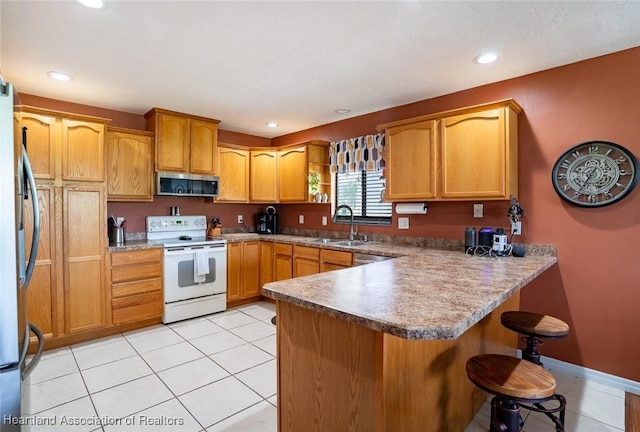 kitchen featuring stainless steel appliances, sink, light tile patterned floors, and kitchen peninsula