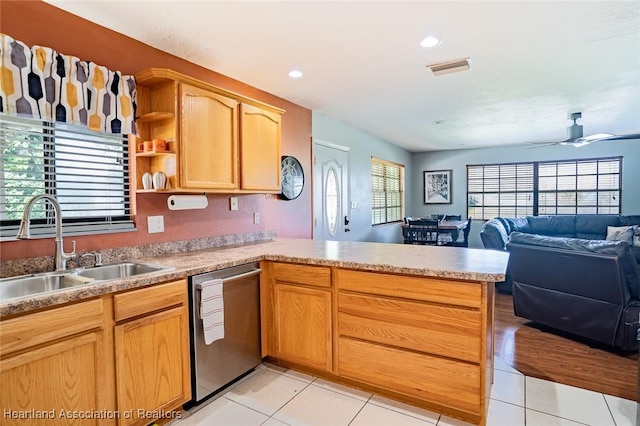 kitchen with dishwasher, sink, light tile patterned floors, ceiling fan, and kitchen peninsula