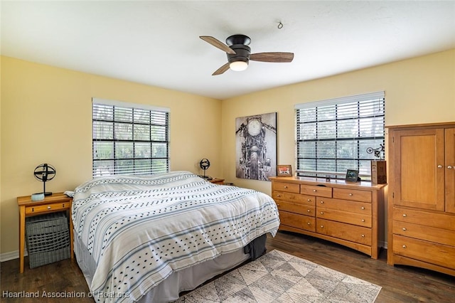 bedroom featuring multiple windows, ceiling fan, and dark hardwood / wood-style flooring