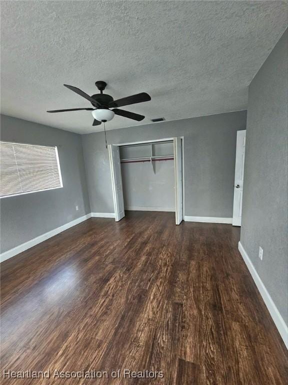 908 Taseschee Dr, Sebring, FL 33870 - unfurnished bedroom featuring a textured ceiling, wood finished floors, a closet, a ceiling fan, and baseboards