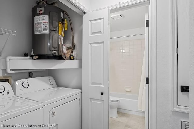 clothes washing area featuring electric water heater, laundry area, and independent washer and dryer