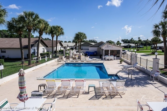 pool featuring fence, a patio area, and a residential view