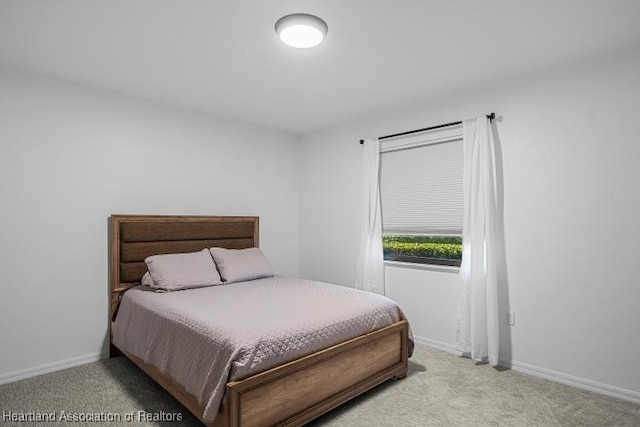 bedroom with light carpet and baseboards