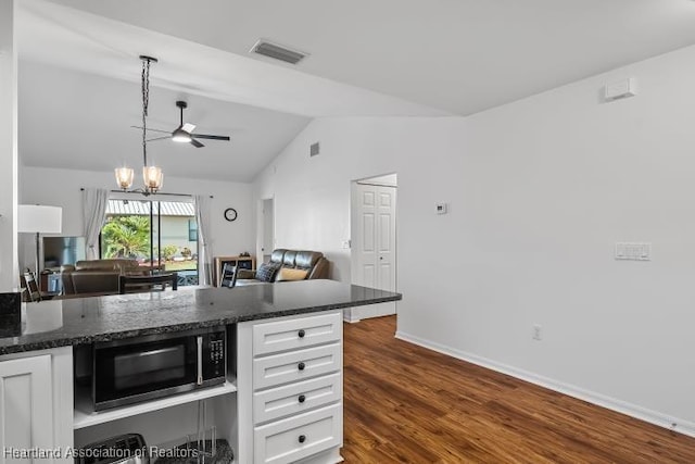 kitchen with lofted ceiling, visible vents, black microwave, open floor plan, and white cabinetry