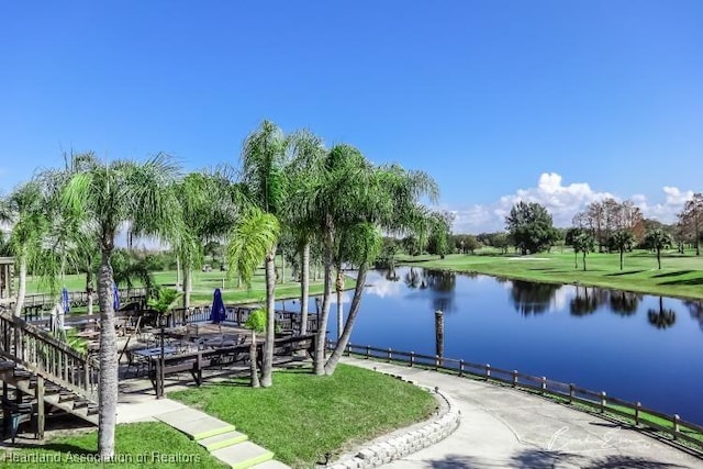 surrounding community featuring a lawn, a dock, and a water view