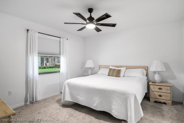 bedroom with a ceiling fan, baseboards, and carpet