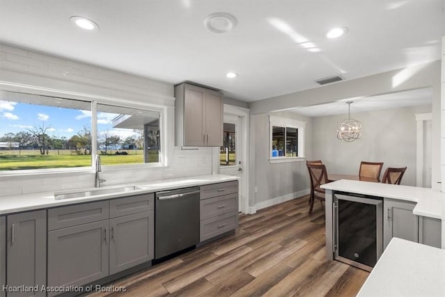 kitchen featuring pendant lighting, sink, gray cabinets, dishwasher, and beverage cooler