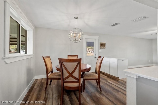 dining space featuring an inviting chandelier and dark hardwood / wood-style flooring