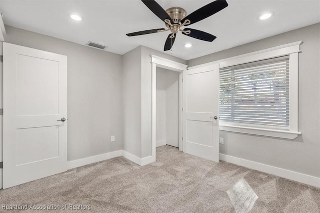 unfurnished bedroom with ceiling fan and light colored carpet