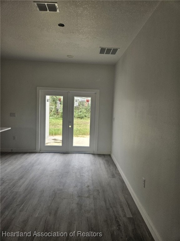 spare room featuring wood-type flooring and french doors