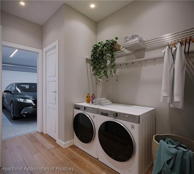 washroom with washer and clothes dryer and light wood-type flooring