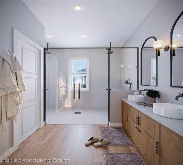 bathroom with vanity, wood-type flooring, and a shower with shower door