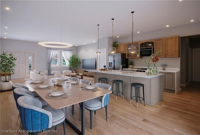 dining space with light wood-type flooring and sink