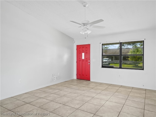 entryway featuring ceiling fan, light tile patterned floors, and a textured ceiling