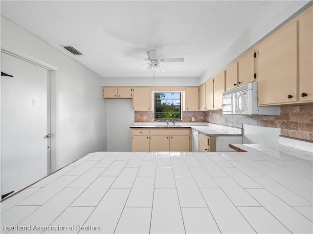 kitchen featuring white appliances, sink, ceiling fan, a textured ceiling, and light brown cabinetry