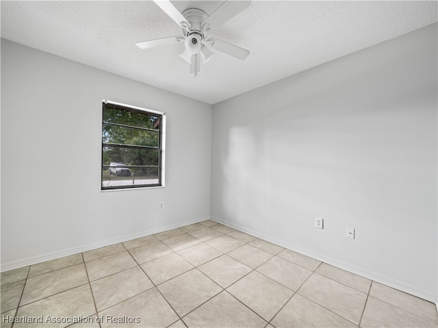 tiled spare room with a textured ceiling and ceiling fan