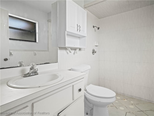 bathroom with walk in shower, vanity, toilet, and tile walls