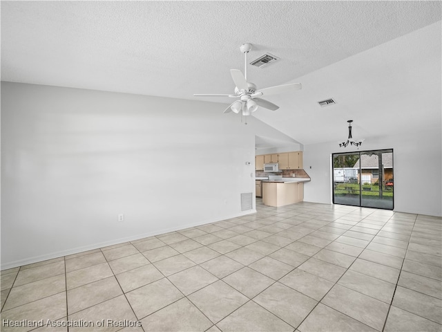 unfurnished living room featuring a textured ceiling, ceiling fan with notable chandelier, lofted ceiling, and light tile patterned flooring