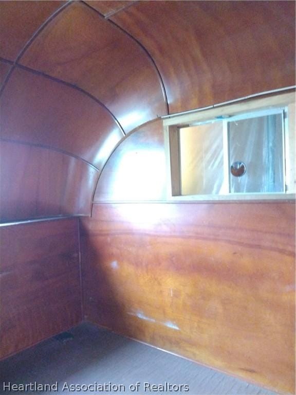 additional living space featuring wood walls