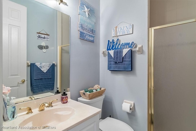 bathroom featuring toilet, vanity, and walk in shower