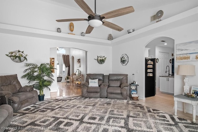 living room with ceiling fan, sink, and light tile patterned floors