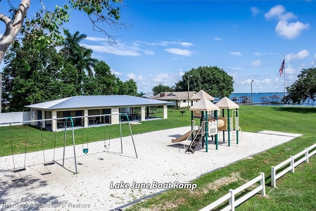 view of jungle gym featuring a water view and a yard