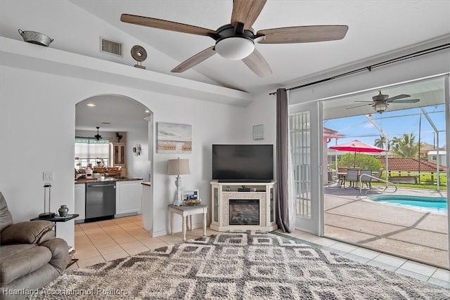 living room with light tile patterned flooring, ceiling fan, and vaulted ceiling