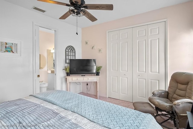 bedroom with light tile patterned floors, ensuite bath, a closet, and ceiling fan