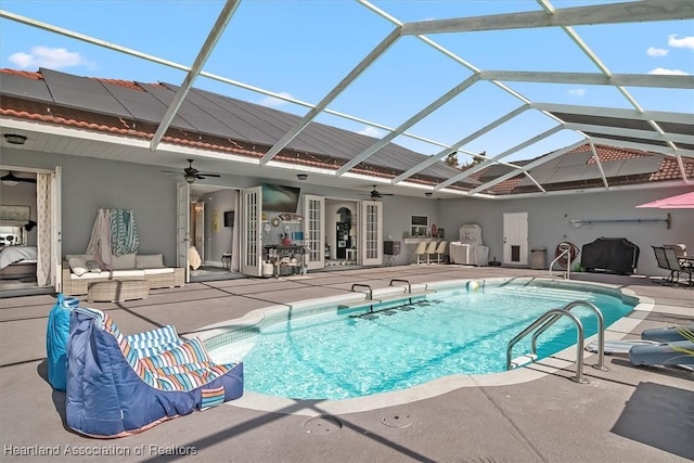 view of pool with a lanai, ceiling fan, and a patio area