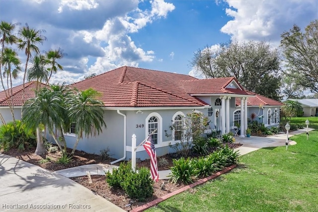 mediterranean / spanish home featuring a front yard