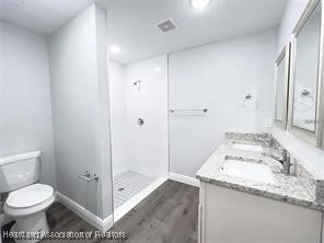 501 Triumph Dr, Sebring, FL 33872 - full bath with wood finished floors, vanity, baseboards, toilet, and a walk in shower