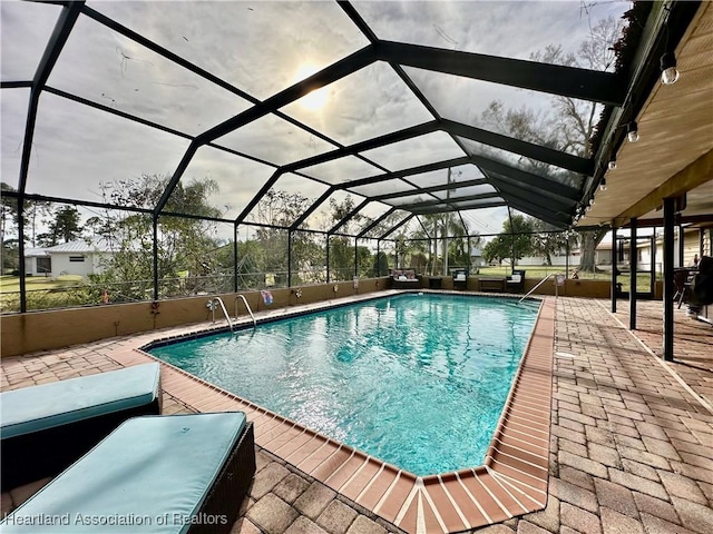 view of swimming pool featuring a lanai and a patio area