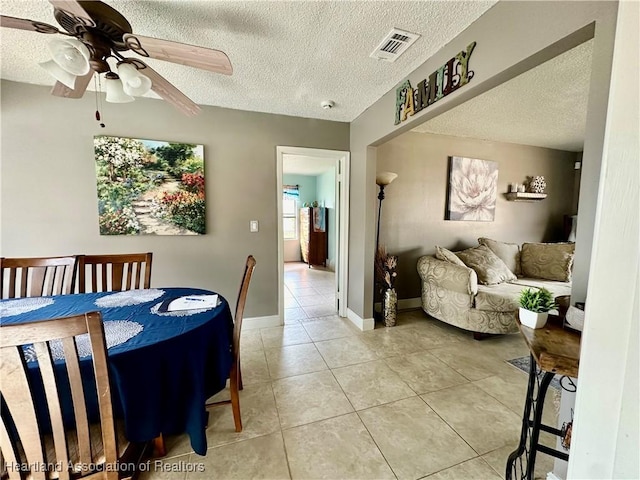 dining area featuring light tile patterned floors, a textured ceiling, and ceiling fan