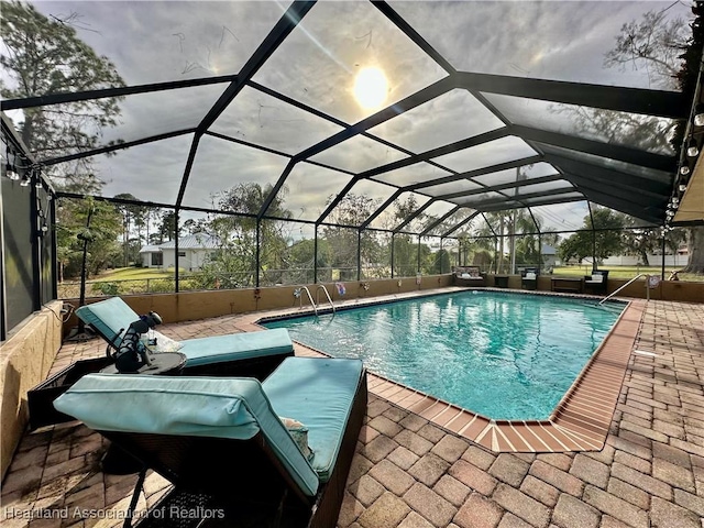 view of swimming pool featuring a patio and glass enclosure