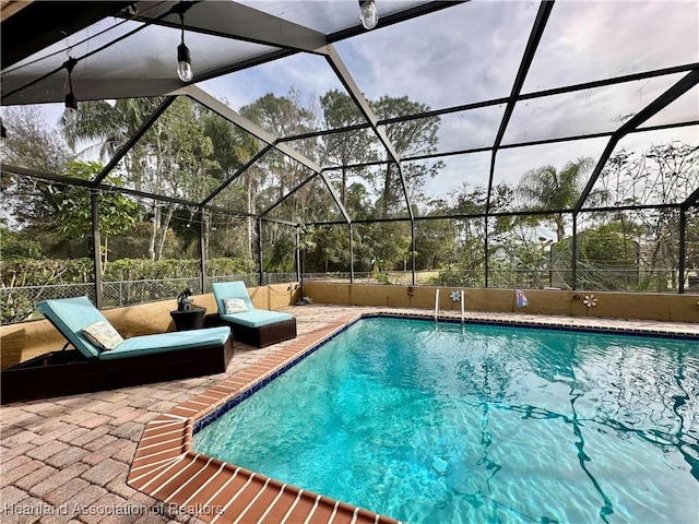 view of swimming pool with a lanai and a patio