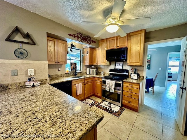 kitchen with sink, light tile patterned floors, ceiling fan, black appliances, and light stone countertops